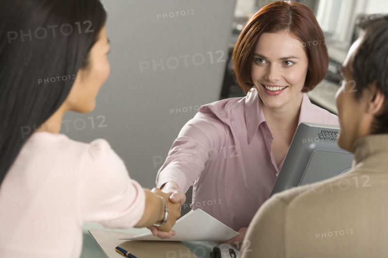 Businesswoman shaking hands in office.