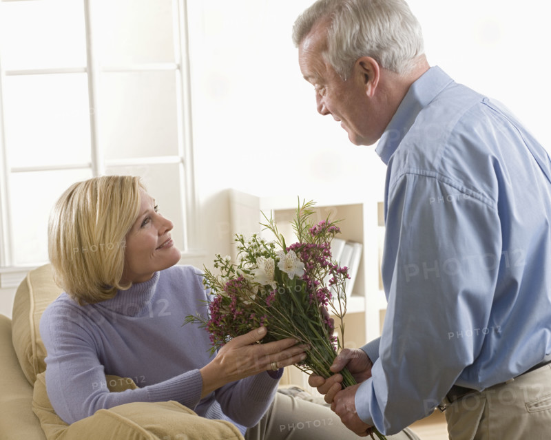 Man giving flowers to his wife.