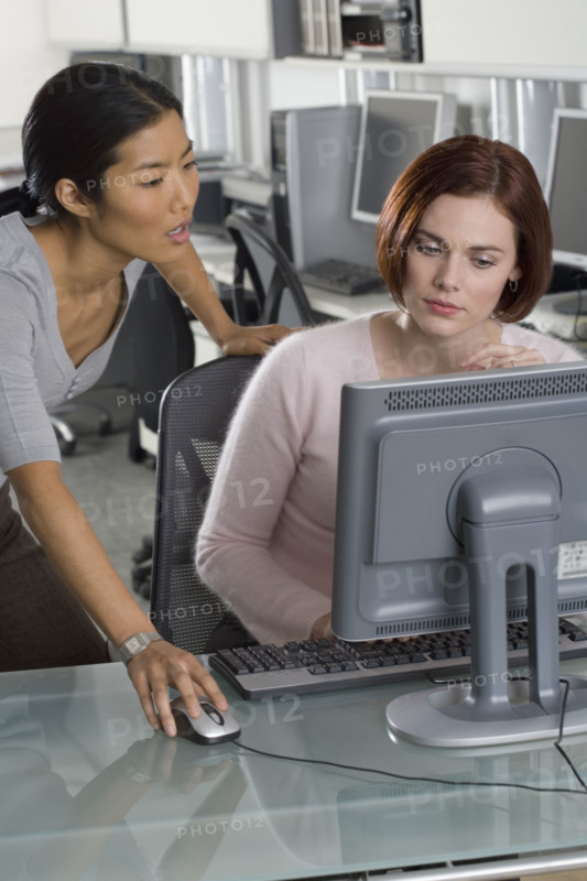 Office workers conferring at computer.