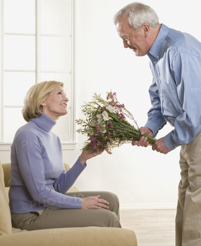Man giving flowers to his wife.