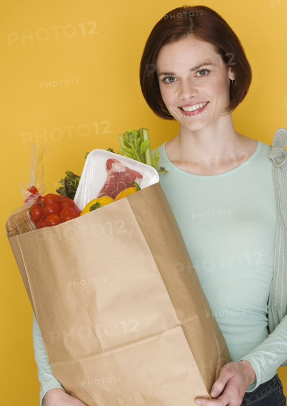 Woman carrying bag of groceries.