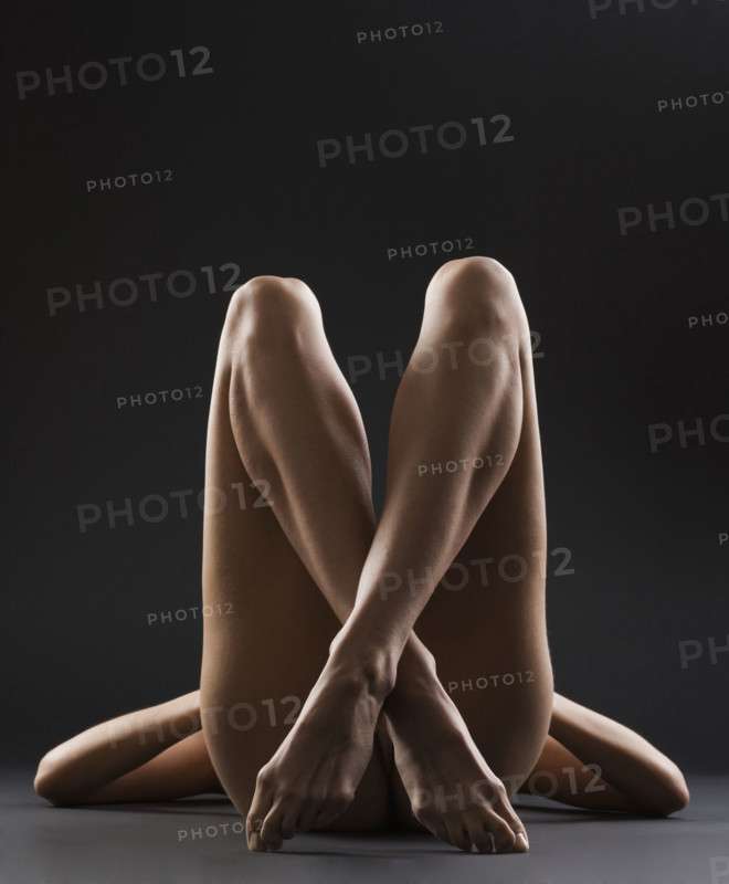 Nude female with legs crossed.