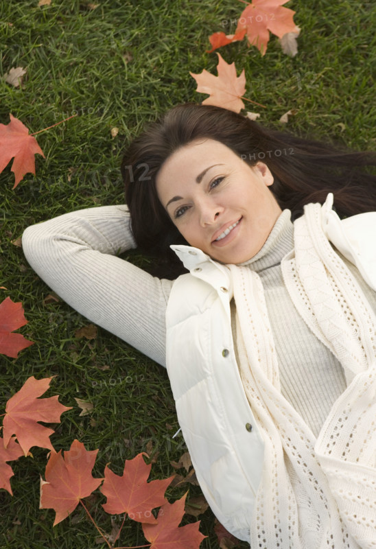 Woman lying on grass on fall day.