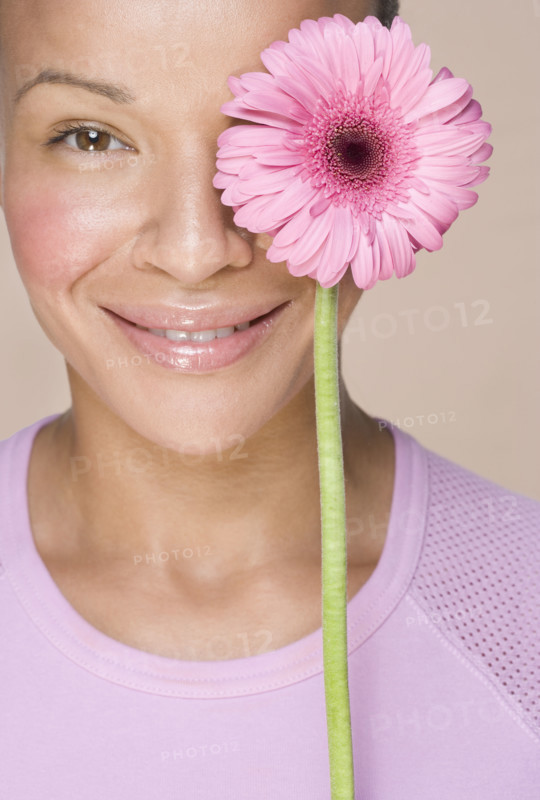 Woman with flower over one eye.