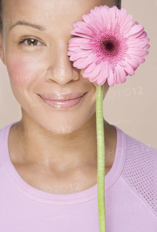 Woman with flower over one eye.