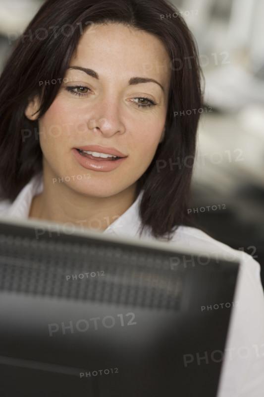 Woman in office looking at computer screen.