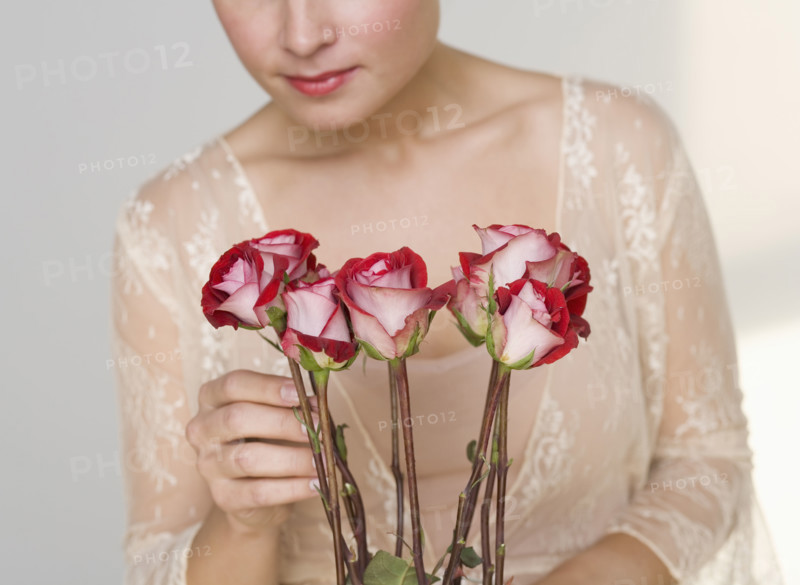 Close up of woman arranging stemmed roses.