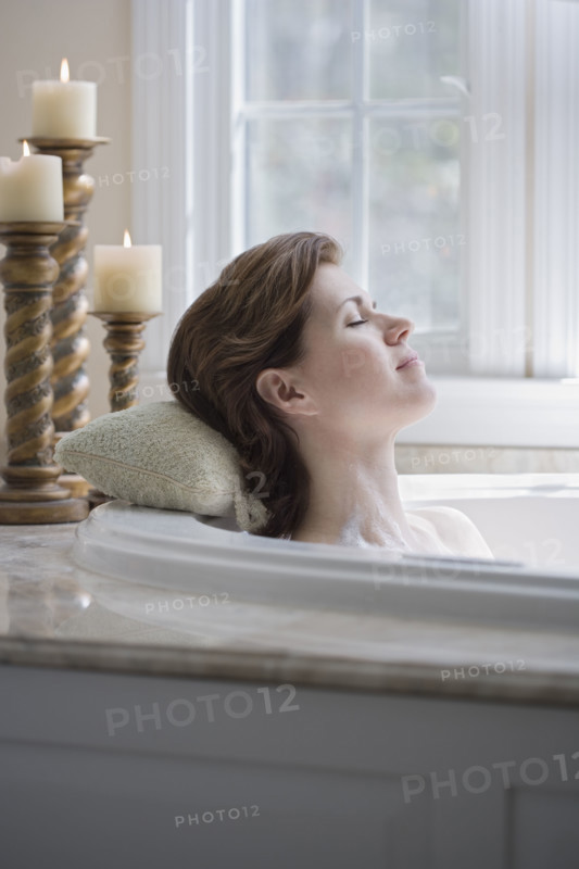 Woman relaxing in bathtub.