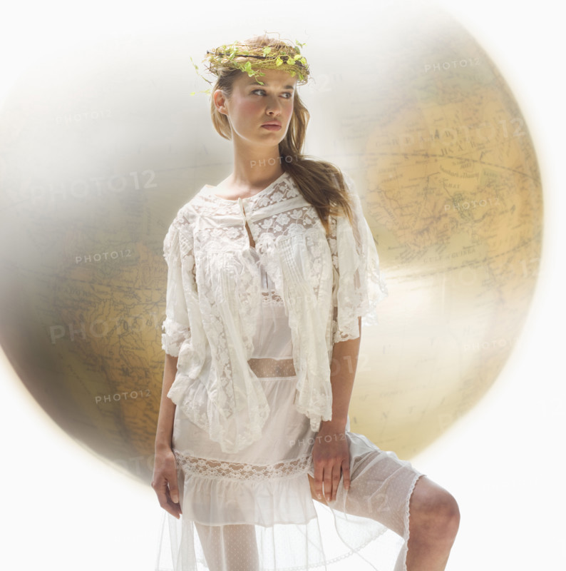 Young female with large globe in background.