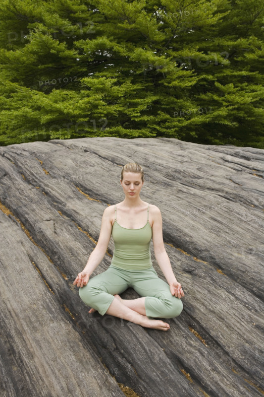 Woman practicing yoga in park.