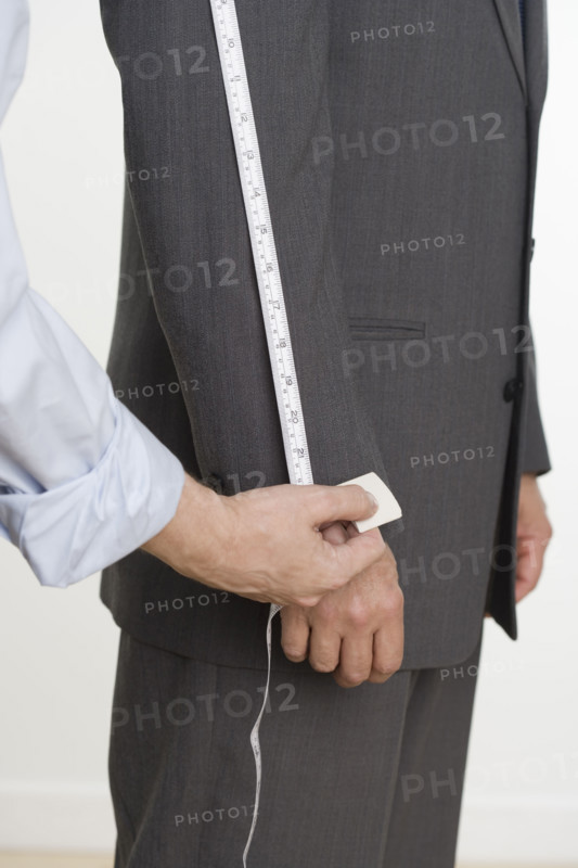 Tailor taking suit measurements.