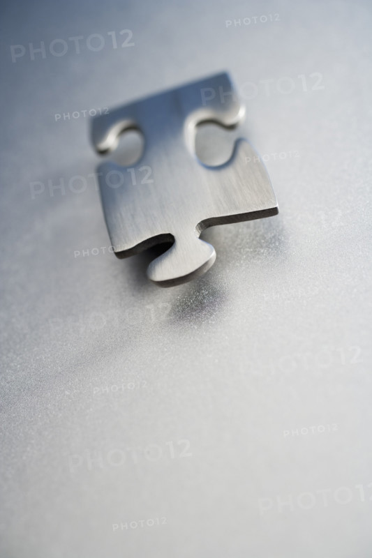 Angled metallic jigsaw puzzle piece .