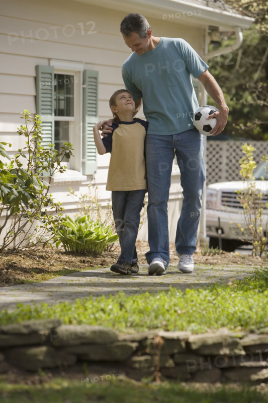 Father and young son with soccer ball.