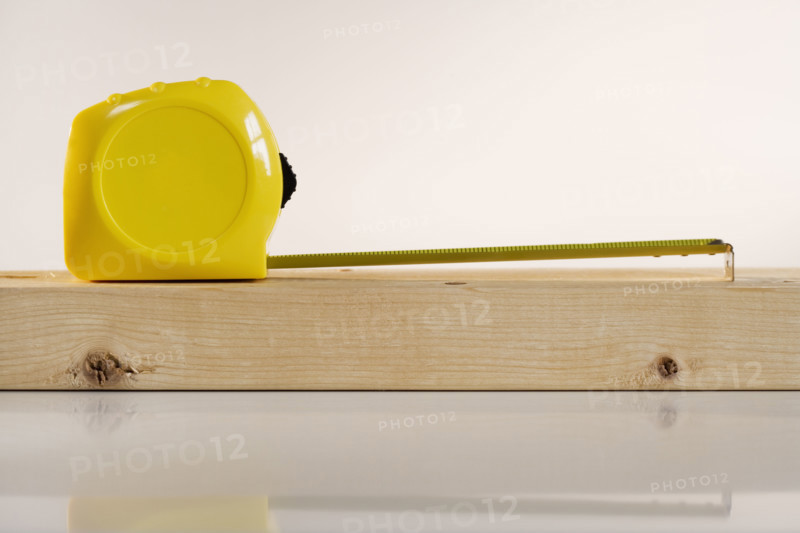 Studio shot of tape measure and wood.