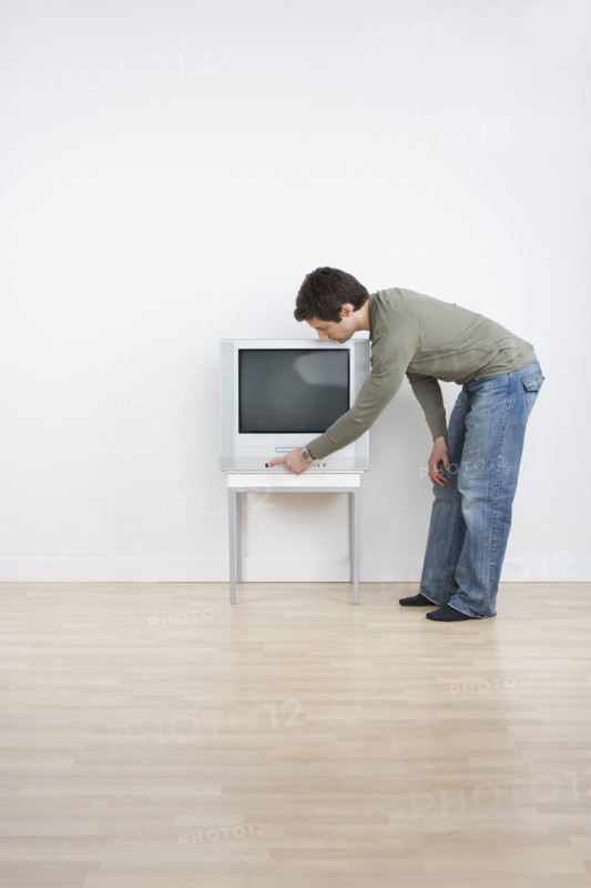 Man turning on television.