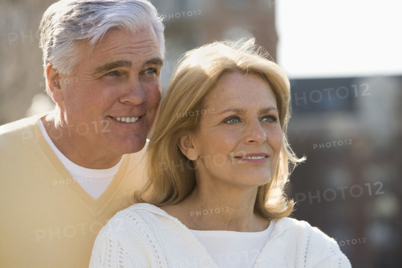 Senior couple smiling outdoors.