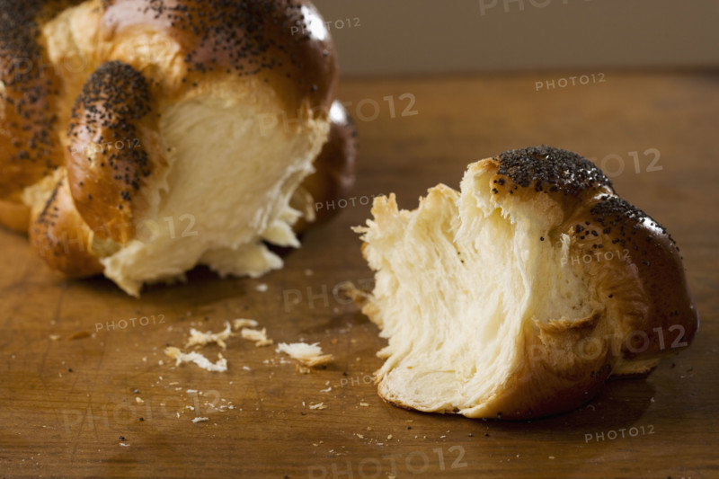 Piece of Challah bread broken off of loaf.