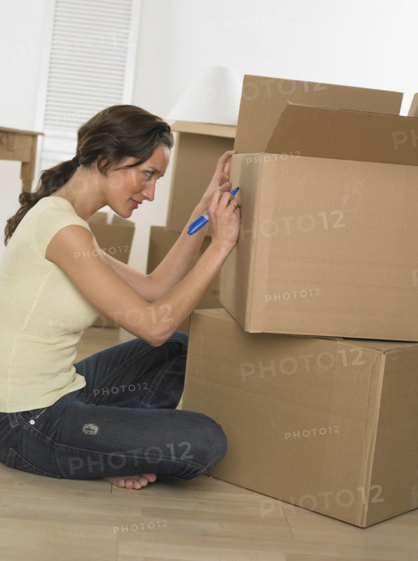 Woman marking boxes on moving day.