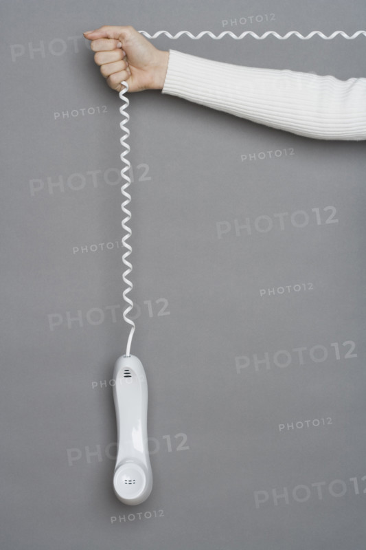 Telephone dangling by cord.