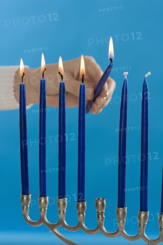 Woman lighting a Menorah.