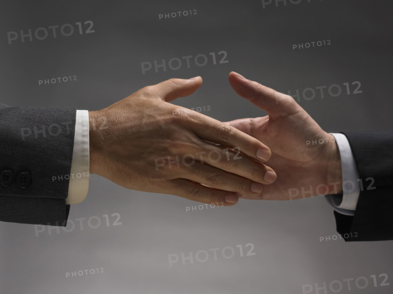 Two men about to shake hands.
