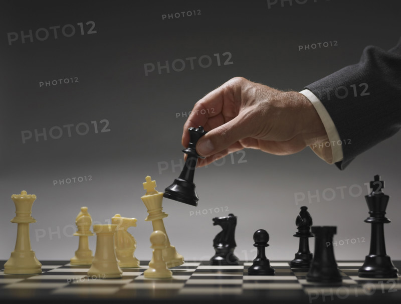Businessman moving chess piece.