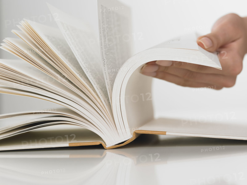 Close up of woman flipping pages in book.