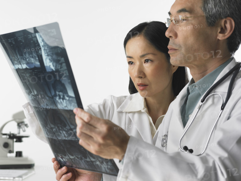 Male and female doctors looking at x-rays.