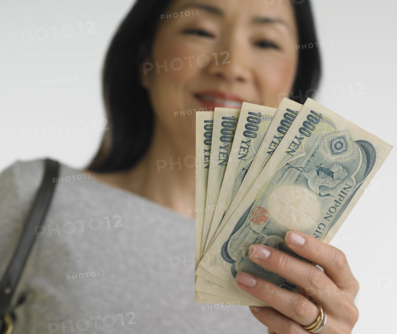 Low angle view of Asian woman holding Japanese money.