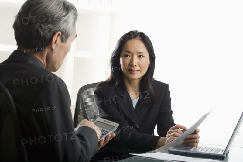 Asian businesswoman talking to businessman.