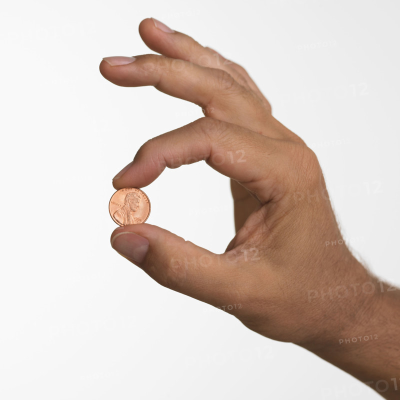 Close up studio shot of man holding penny.