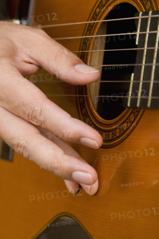 Close up of man's hand playing guitar.