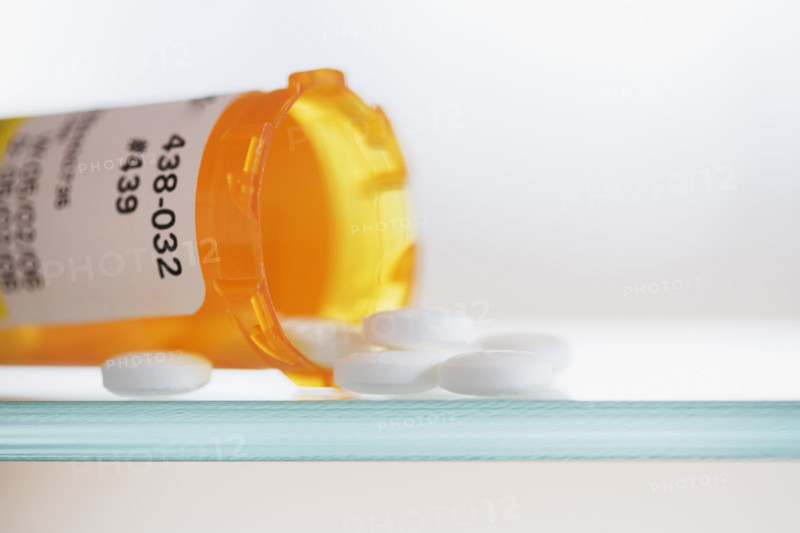 Close up of pills spilling out of medication bottle.