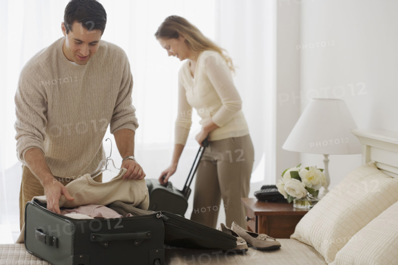 Couple unpacking in hotel room.