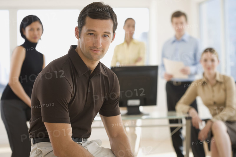 Portrait of businessman with coworkers in background.
