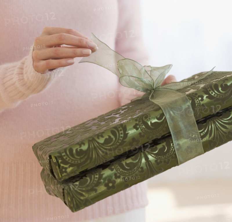 Close up of woman opening gift.