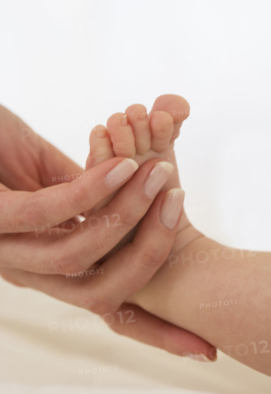 Mother holding baby’s foot.