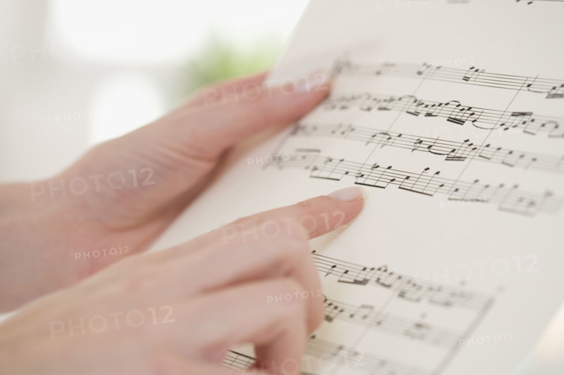 Close up of woman pointing at sheet music.