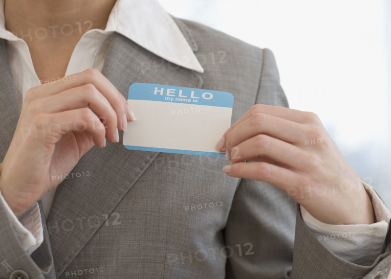Businesswoman putting on Hello My Name Is sticker.