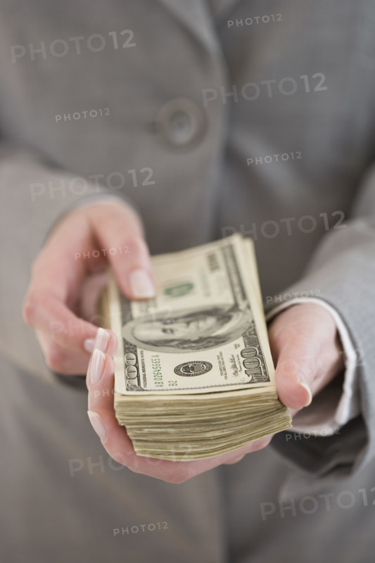 Businesswoman holding stack of money.