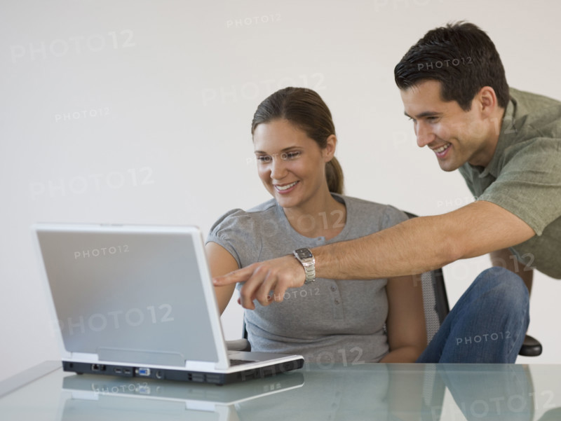 Couple pointing at laptop.