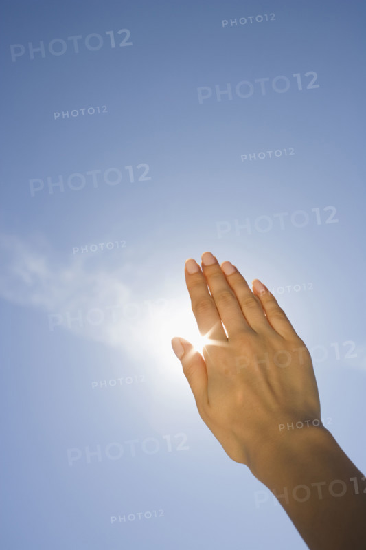 Close up of woman's hand blocking sun.