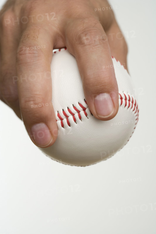 Close up of pitcher holding baseball.