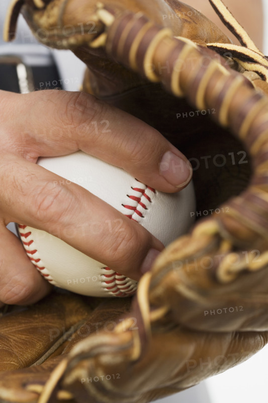 Close up of man with baseball glove and baseball.