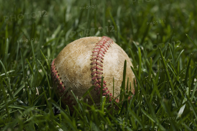 Close up of baseball in grass.