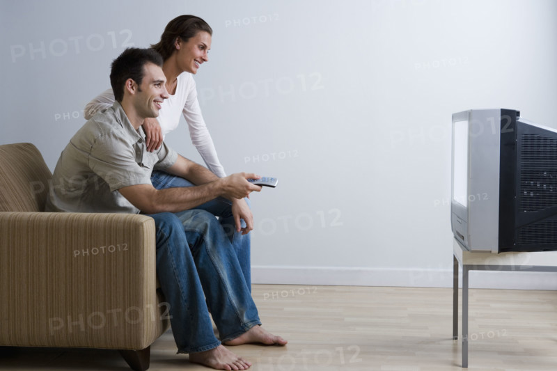 Couple on sofa watching television.