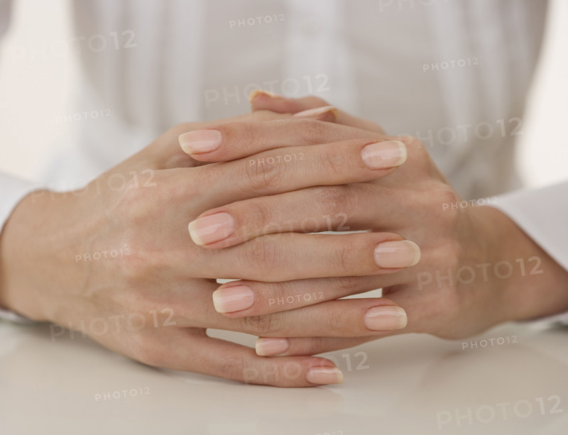 Close up of woman’s hands clasped.