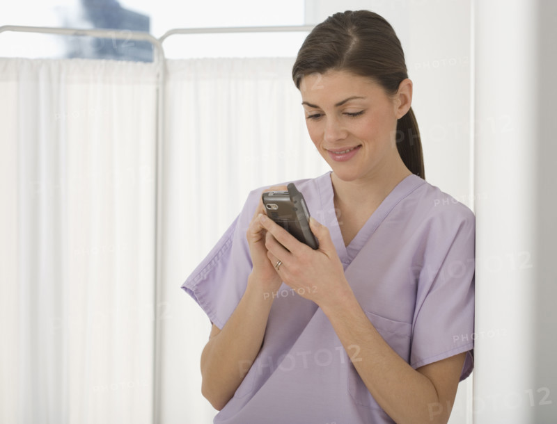 Female doctor looking at electronic organizer.