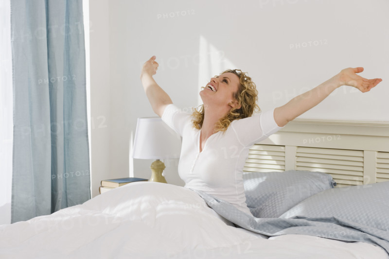 Woman stretching in bed.