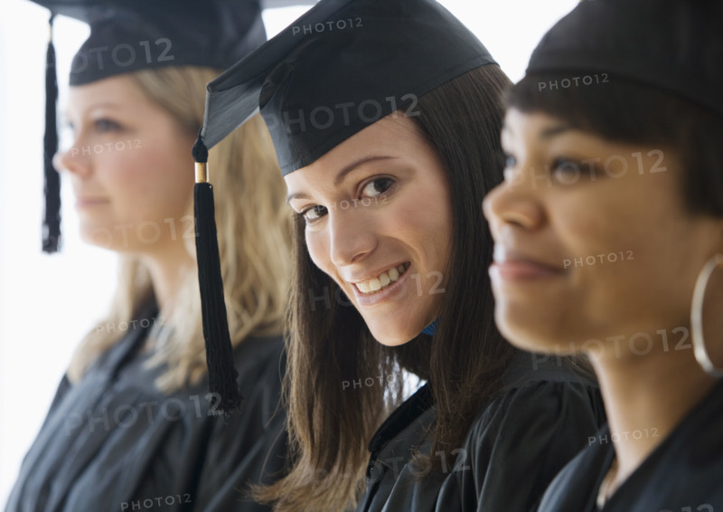 Multi-ethnic women wearing graduation cap and gown.